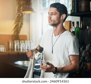 Waiter, man and cleaning a glass in pub with thinking, daydreaming and wondering with hygiene and maintenance. Bartender, person and thoughtful in restaurant with polishing, disinfection and bacteria - Powered by Shutterstock