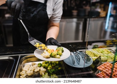 The waiter man or woman puts the food on a plate. Breakfast buffet concept, brunch with Family. People catering buffet food indoors in a luxury restaurant. Catering and Dining. Celebration party. - Shutterstock ID 2139648487