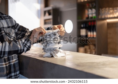 Waiter Organizing Stack of Paper Orders at Busy Restaurant Bar During Lunchtime Rush