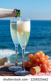 Waiter Pouring Champagne, Prosecco Or Cava In Two Glasses On Outside Terrace With Sea View  Close Up