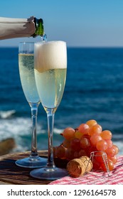 Waiter Pouring Champagne, Prosecco Or Cava In Two Glasses On Outside Terrace With Sea View  Close Up