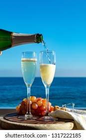 Waiter Pouring Champagne, Prosecco Or Cava In Two Glasses On Outside Terrace With Sea View  Close Up