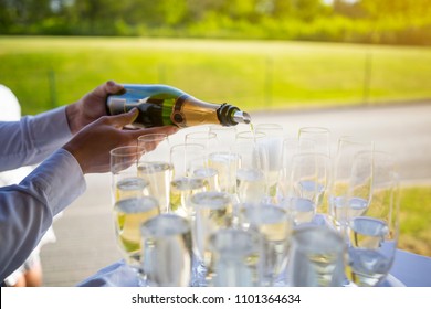 Waiter Pouring Champagne Or Sparkling Wine To Glasses At An Outdoor VIP Event