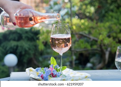 Waiter Pouring A Glass Of Cold Rose Wine, Outdoor Terrace, Sunny Day, Green Garden Background