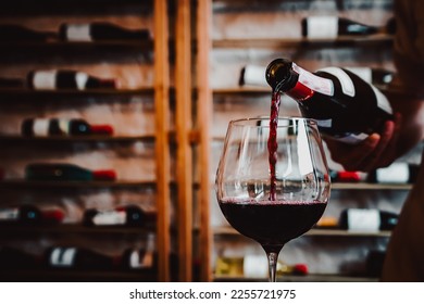 Waiter pouring red wine in glasses for wine on the table in restaurant - Powered by Shutterstock