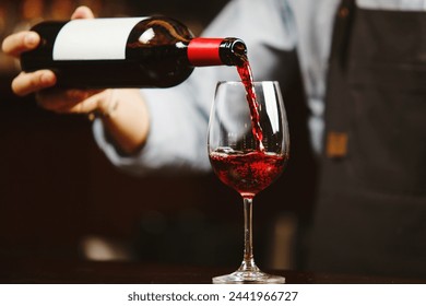 Waiter pouring red wine into wineglass. Sommelier pours alcoholic drink - Powered by Shutterstock