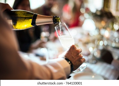 A waiter pouring sparkling wine