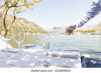 Waiter pouring water from bottle in the restaurant