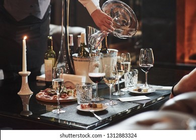 Waiter Pours Wine Into The Glass In The Luxury Restaurant With Special Visitors In There.