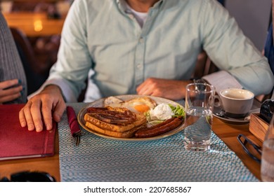 The Waiter In The Restaurant Brings Lunch To The Whole Family Of Three. Family Launch Concept.