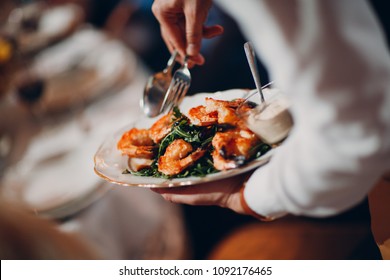 Waiter serves shrimp with arugula - Powered by Shutterstock