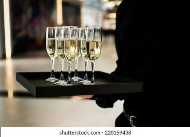 Waiter serving champagne on a tray in restaurant