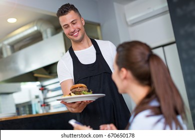 Waiter Serving Customer At Restaurant
