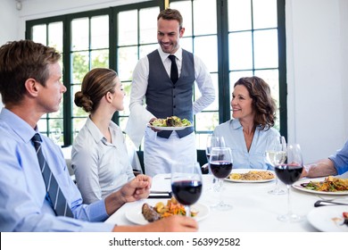 Waiter serving salad to the business people in restaurant - Powered by Shutterstock