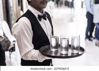 Waiter serving water and beer