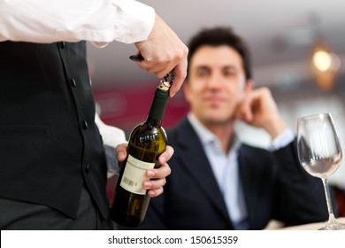 Waiter Serving Wine To A Customer At The Restaurant