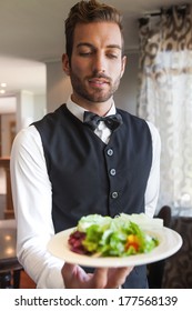 Waiter Showing Bowl Of Salad To Camera In A Fancy Restaurant