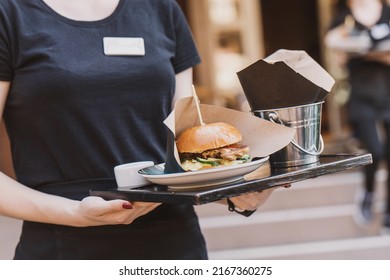 The Waiter Takes The Burger To The Outdoor Summer Area In The Cafe. Street Fast Food