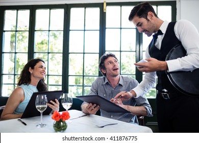 Waiter taking an order for a couple in a restaurant - Powered by Shutterstock