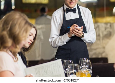 Waiter taking an order for a couple in a restaurant
