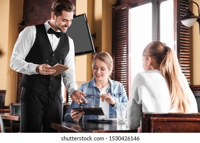 Waiter Taking Order In Restaurant