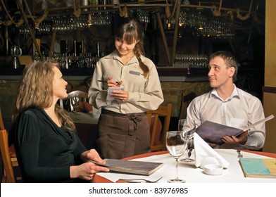 A waiter taking order from restaurant customers