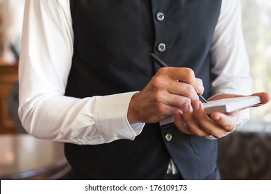 Waiter Taking An Order Wearing A Waistcoat In A Fancy Restaurant