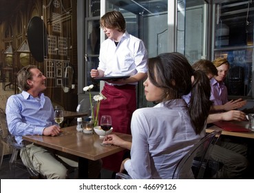 Waiter Taking Orders From A Customer In A Restaurant