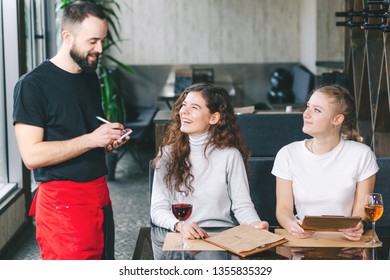 Waiter taking orders from young woman customer in restaurant - Powered by Shutterstock