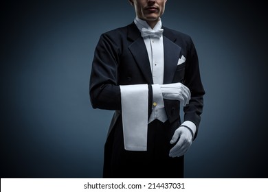 Waiter in a tuxedo on a black background