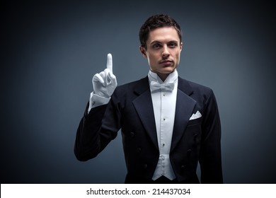 Waiter in a tuxedo on a black background