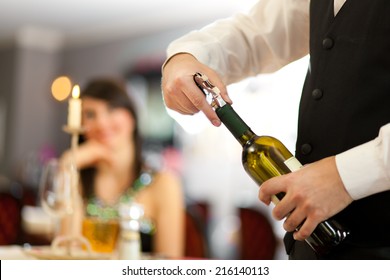 Waiter Uncorking A Wine Bottle In A Restaurant