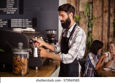 Waiter using a coffee machine in the bar - Powered by Shutterstock