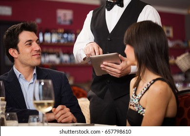 Waiter Using A Tablet To Take An Order