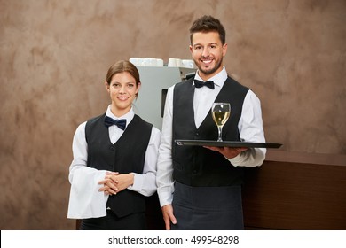 Waiter and waitress serving white wine in a hotel restaurant - Powered by Shutterstock