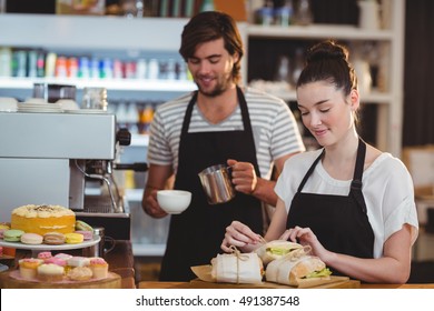 Waiter and waitress working behind the counter in caf? - Powered by Shutterstock