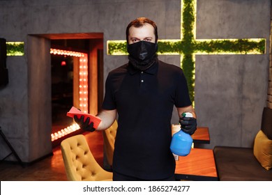 Waiter wearing protective face mask and gloves while disinfecting tables indoor restaurant, cafe. Precautions during the covid-19 coronavirus pandemic. - Powered by Shutterstock