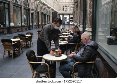 A Waiter, Wearing A Protective Mask, Serves A Customer As Restaurants And Bars Reopen After Weeks Of Lockdown Restrictions Amid The Coronavirus Disease In Brussels, Belgium On Jun. 8, 2020.