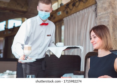 The Waiter Works In A Restaurant In A Medical Mask