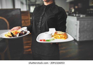 Waiters carrying plates with meat dish at a wedding.