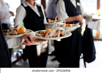 Waiters carrying plates with meat dish at a wedding - Shutterstock ID 295106906