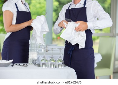 waiters cleaning glasses in a restaurant - Powered by Shutterstock