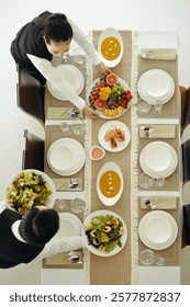 Waiters Setting Dining Table During Catering Service