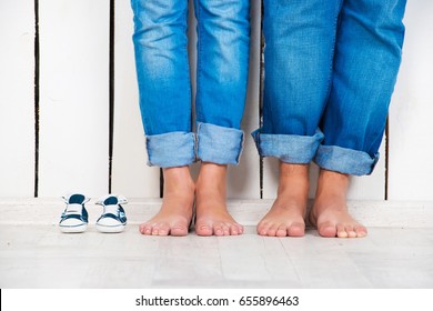 Waiting of baby. Pregnant woman, pregnancy, motherhood. Happy family. Mom's, Dad's and baby's bootees. Family look