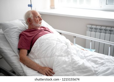 Waiting For Doctor. Side View Portrait Of Serious Old Man Resting In Recovery Room