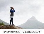 Waiting for the echo.... Shot of a young man shouting on a mountain top.