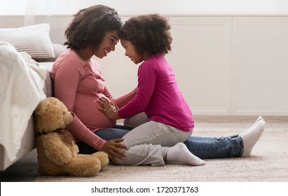 Waiting For Second Baby. Side View Portrait Of Happy Pregnant Black Woman And Her Little Daughter Bonding Together At Home, Copy Space