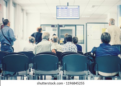 Waiting The Turn In A Hospital. Back View Of Sitting Group Of People