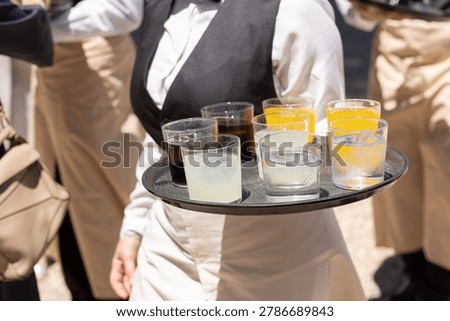 Waitress Carrying Assorted Cold Drinks at Outdoor Catering Event