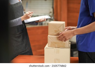 Waitress Check And Receive The Package Box With Checklist From Food Supply Delivery Man To Restaurant 